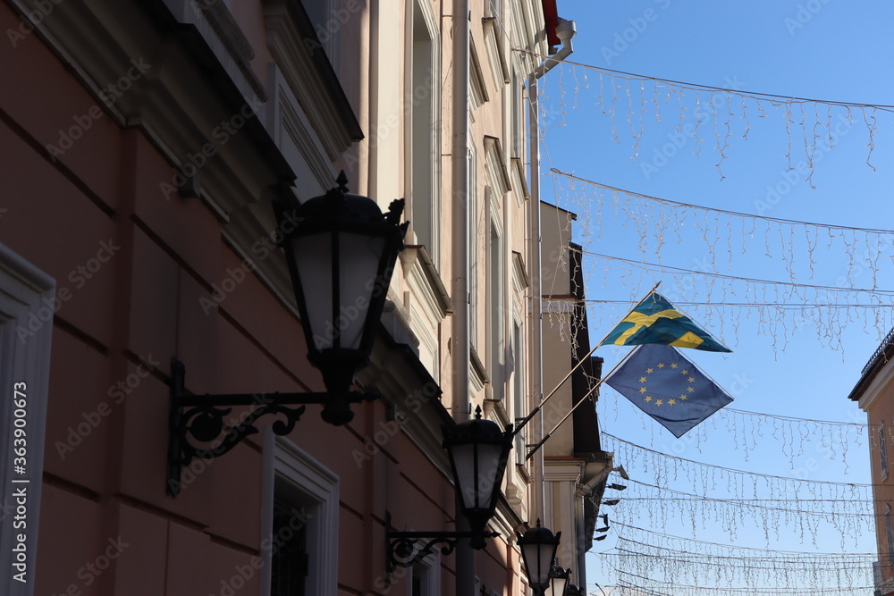 swedish and EU flag fluttering on building wall