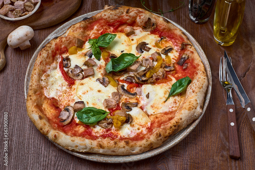 Pizza Turkey breast, mushrooms and mozzarella, smoked papillon cheese on black concrete background.