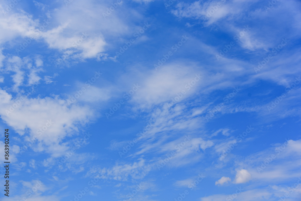 Cloudscape. Blue sky with large and small white clouds. Beautiful clouds slowly float against the blue sky.