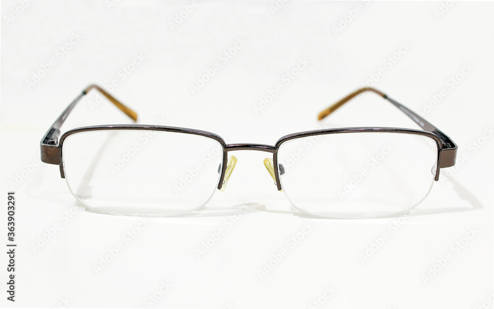 Transparent metallic glasses on bright background. Close up of used reading eyeglasses Transparent metallic glasses on bright background. Close up of used reading eyeglasses