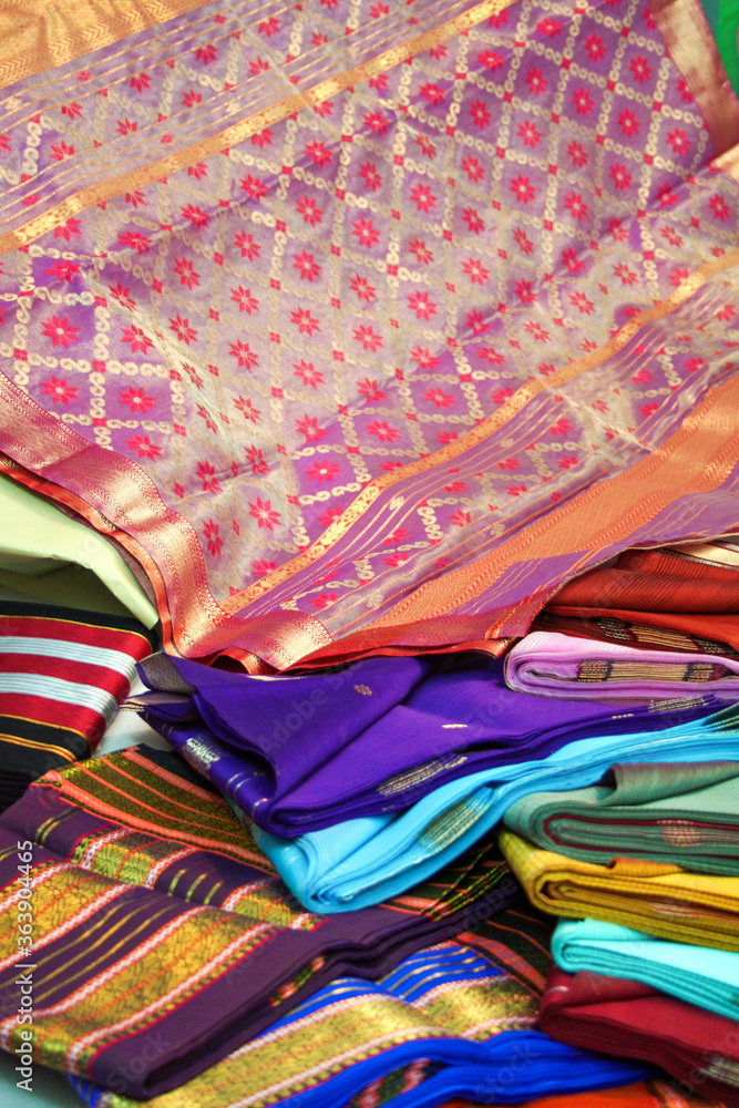 Maheshwari saris in a textile shop, displayed in front of customers. Maheshwar, Madhya Pradesh, India. Maheshwari saris in a textile shop, displayed in front of customers. Maheshwar, Madhya Pradesh, India.
