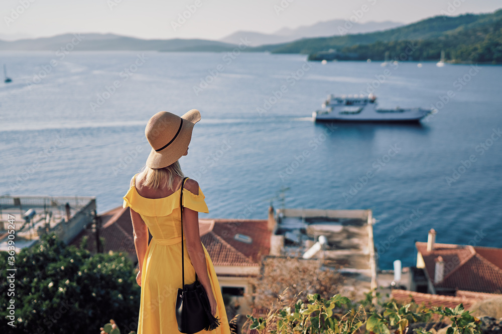 Enjoying vacation in Greece. Young traveling woman enjoying sea view.