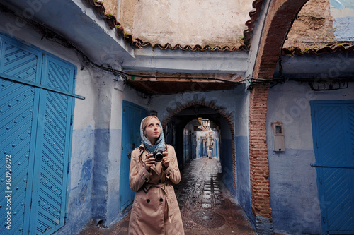 Traveling by Morocco. Young woman walking in medina of blue city Chefchaouen. © luengo_ua