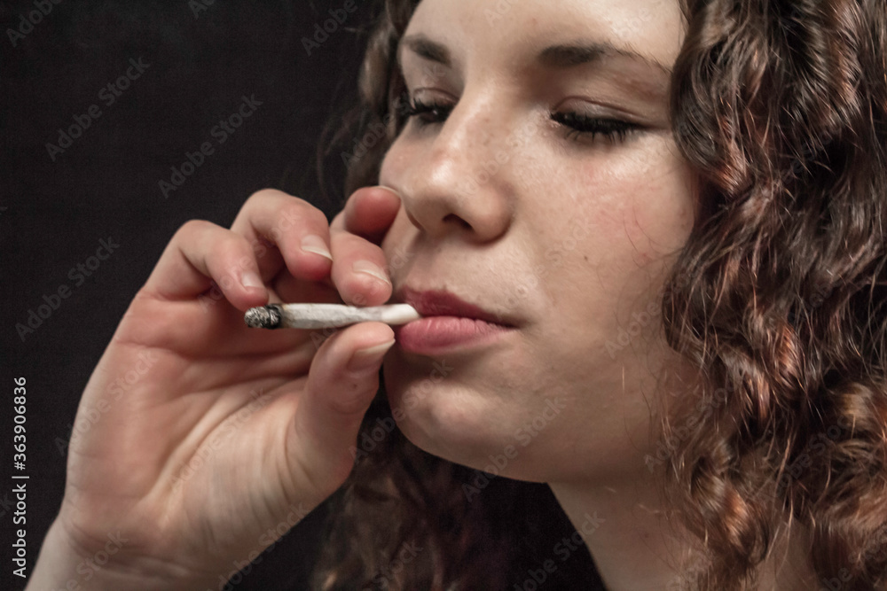 Junge Frau mit Zigarette zwischen Ihren Sinnlichen Lippen Junge Frau mit Zigarette zwischen Ihren Sinnlichen Lippen