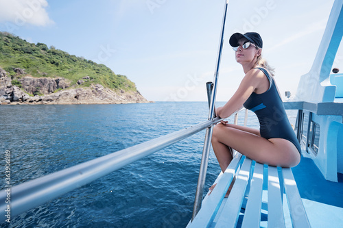 Young happy woman on yacht deck sailing the sea.