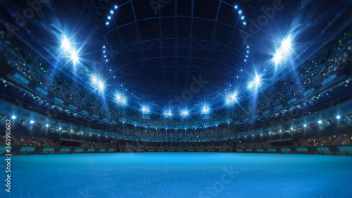 Valokuva Sport stadium with grandstands full of fans, shining night lights and blue artificial surface