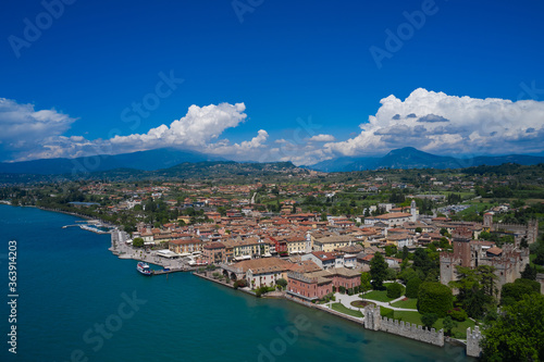 Lazise  Lake Garda  Italy. Aerial view of the historic part of Scaliger Castle of Lazise in the background cumulus clouds in the blue sky