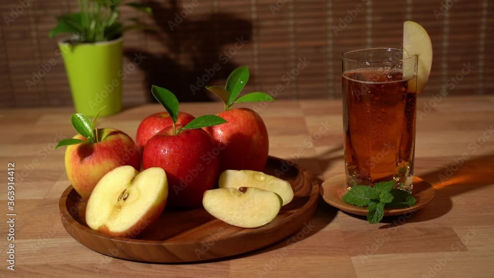 Glass of apple juice and a red apple on the wooden tray. Glass of apple juice and a red apple on the wooden tray.