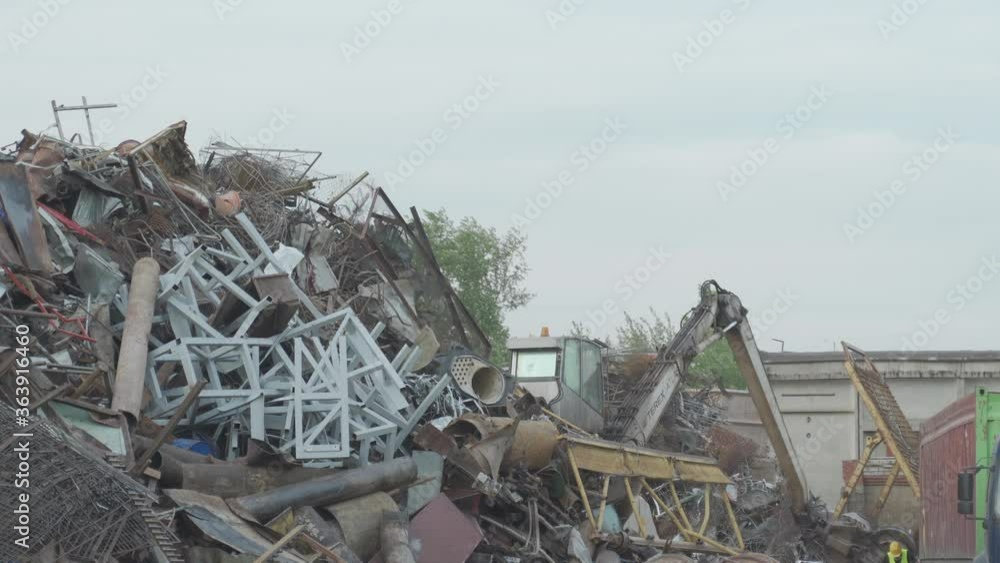View on machine, loader manipulator with hydraulic grappling claw until is collecting, moving old steel, scrap metal. View on machine, loader manipulator with hydraulic grappling claw until is collecting, moving old steel, scrap metal.