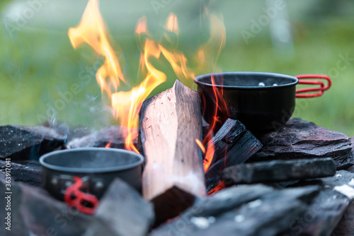 Pots and Pans cooking atop a wood burning camp fire in the English Countryside / wilderness