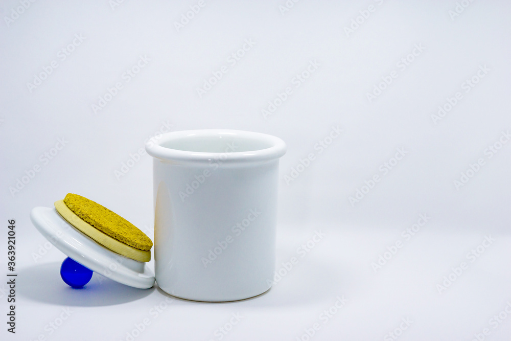 White porcelain pot with a blue knob on the lid isolated on white background. White porcelain pot with a blue knob on the lid isolated on white background.