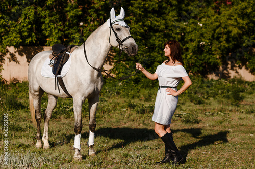 Woman in white dress and beautiful summer white horse © Alyona