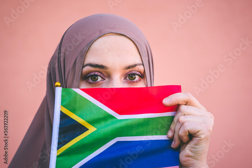 Muslim woman in hijab holds flag of South Africa photo