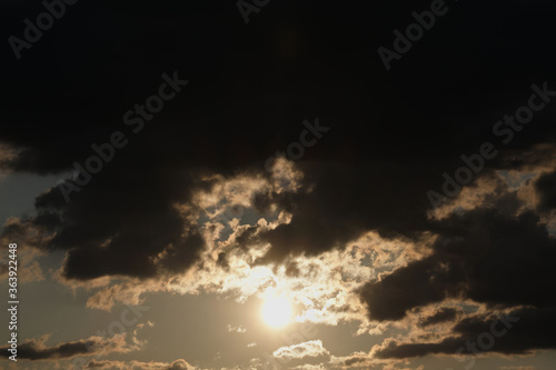 Sunrise on a background of dark gray clouds. Sun, rays of the sun on the background of gray clouds