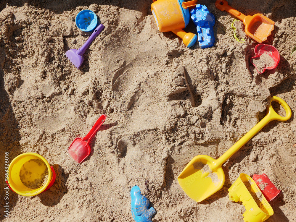 Childrens toys scattered in the sandbox Childrens toys scattered in the sandbox