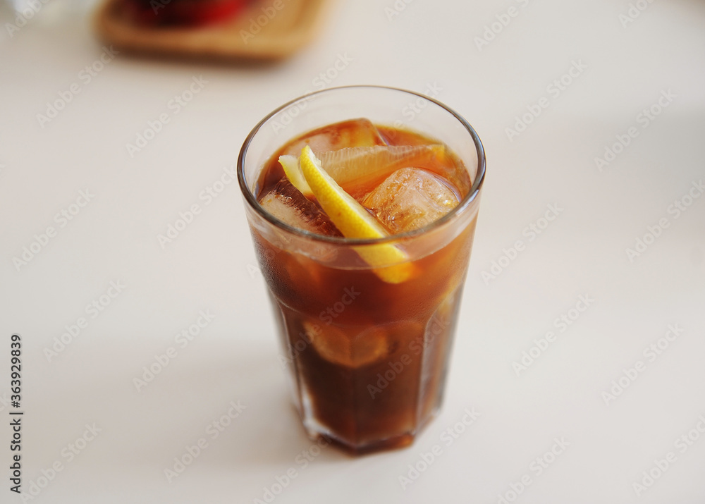 Espresso tonic with lemon slice in bid glass with ice Espresso tonic with lemon slice in bid glass with ice