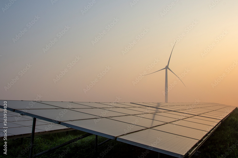 Fototapeta premium Wind power and solar power plants at sunrise and sunset