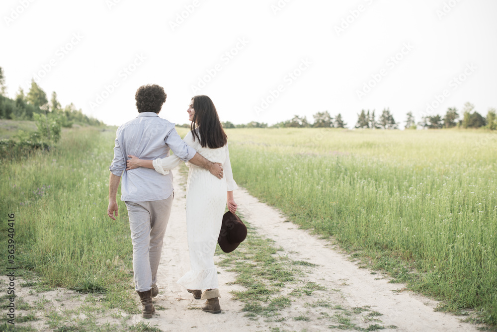 A couple in love go hand in hand to horizon. View from back. Soft selective focus. A couple in love go hand in hand to horizon. View from back. Soft selective focus.