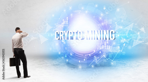 Rear view of a businessman standing in front of CRYPTO MINING inscription  modern technology concept