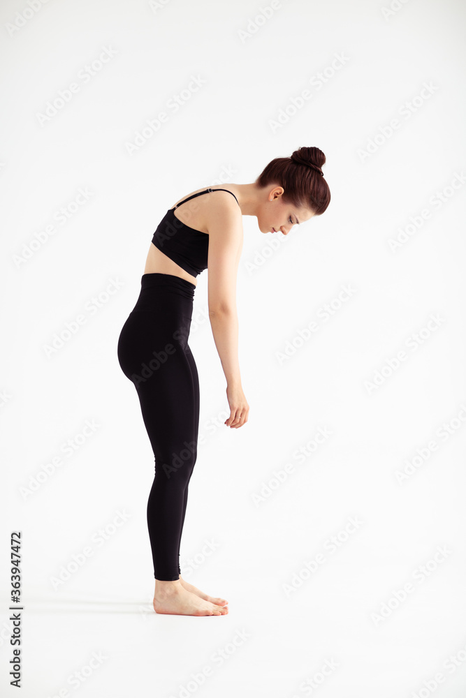 Sporty yoga girl on white background stretching in pose Adho Mukha Svanasana, downward-facing dog Pose, downward dog, down dog. Concept of healthy life and natural balance. Full length Sporty yoga girl on white background stretching in pose Adho Mukha Svanasana, downward-facing dog Pose, downward dog, down dog. Concept of healthy life and natural balance. Full length