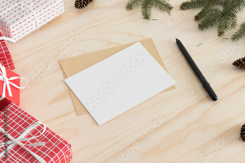 White card mockup with christmas decoration on a wooden table. photo