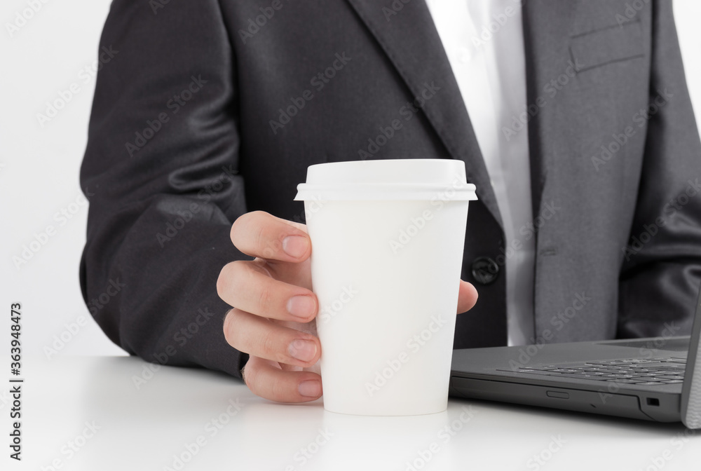 White coffee paper cup mockup with man working on a computer. White coffee paper cup mockup with man working on a computer.
