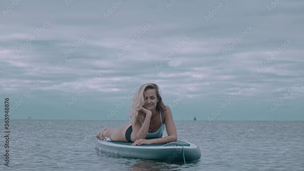 woman performs exercises from yoga on a surfboard. Yoga surf workout woman performs exercises from yoga on a surfboard. Yoga surf workout