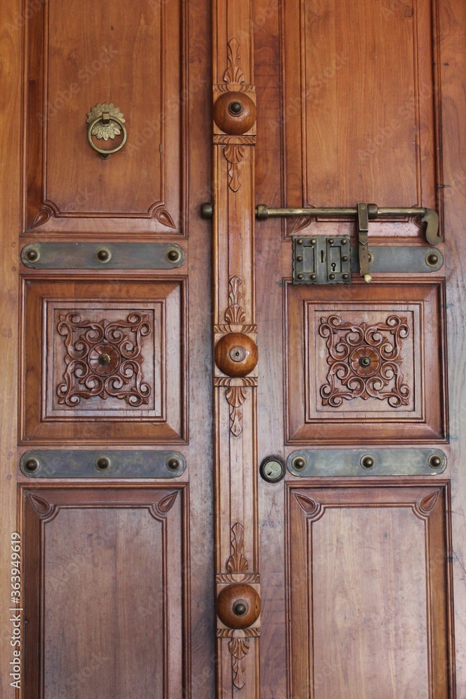 carved old wooden door with bronze doorknob