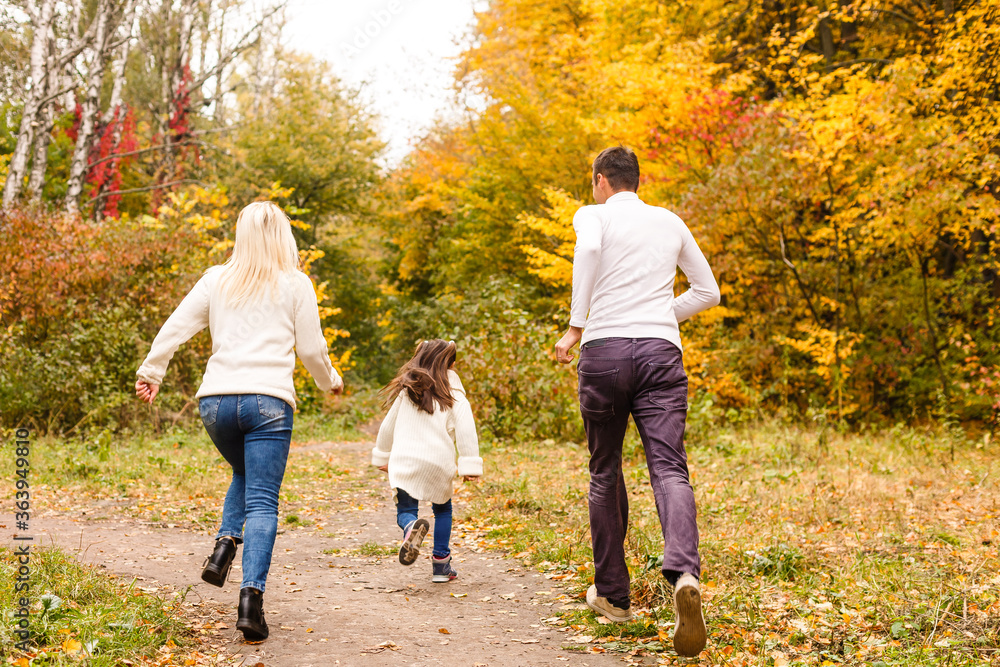 Picture of lovely family in autumn park, young parents with nice adorable daughter playing outdoors, have fun on backyard in fall, happy family enjoy autumnal nature