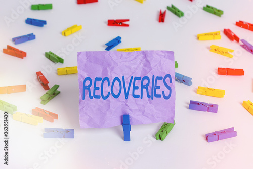 Writing note showing Recoveries. Business concept for process of regaining possession or control of something lost Colored clothespin papers empty reminder white floor background office photo