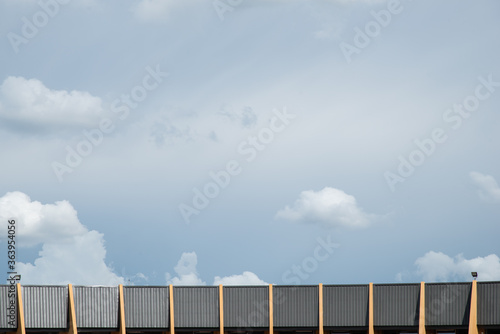 black spotlight install to top of yellow and black metal sheet building in bottom with blue sky cloudy weather stock photo