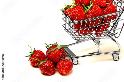 Strawberry. Sweet organic fragrant strawberries in a mini-cart for shopping isolated on a white background close-up. Concept of buying fresh fruits online.