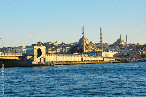 The Galata Bridge in the low late afternoon summer sun. Yeni and Nuruosmaniye mosques can be seen in the background in Eminonu district