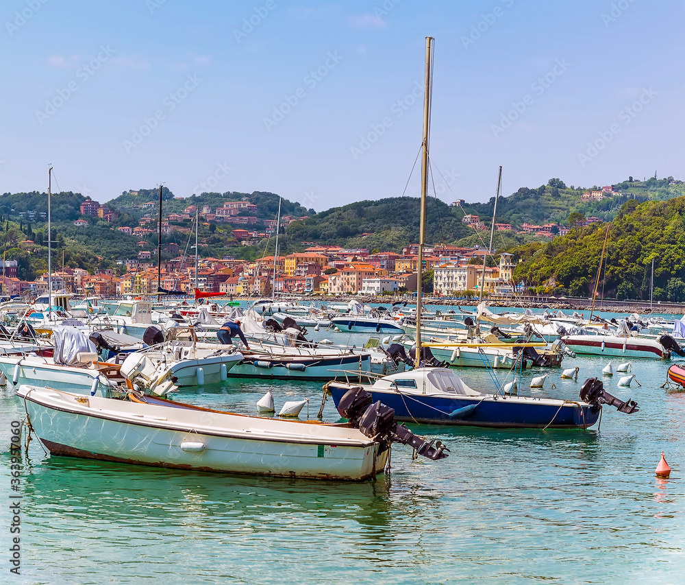 A view across boats moored in the Bay of Poets towards San Terenzo, Italy in the summertime