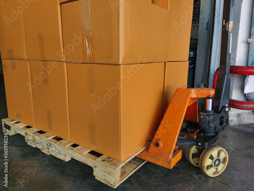 Shipment cartons box on pallets and wooden case on hand lift in interior warehouse cargo for export and sorting goods in freight logistics and transportation industrial