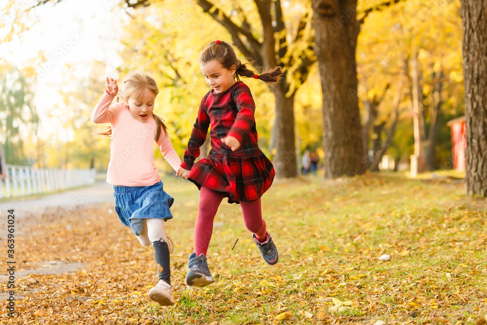two little girls in autumn park two little girls in autumn park