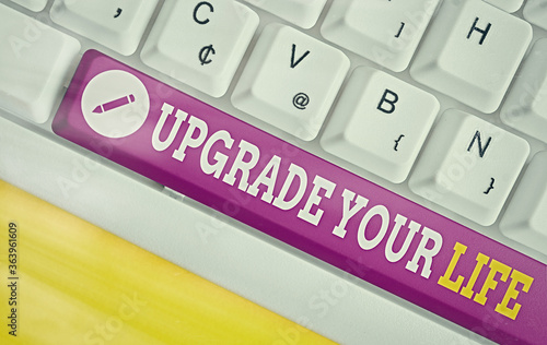 Text sign showing Upgrade Your Life. Business photo text improve your way of living Getting wealthier and happier Different colored keyboard key with accessories arranged on empty copy space photo