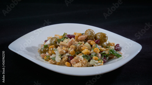 Salad of red and white beans, corn and olives on a white plate