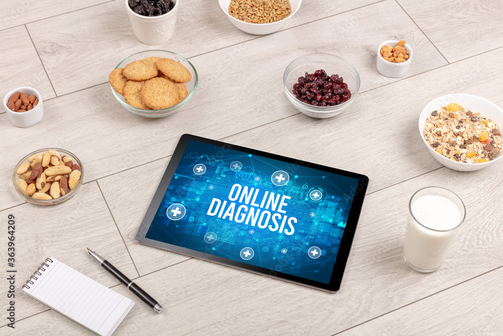 ONLINE DIAGNOSIS concept in tablet pc with healthy food around, top view ONLINE DIAGNOSIS concept in tablet pc with healthy food around, top view