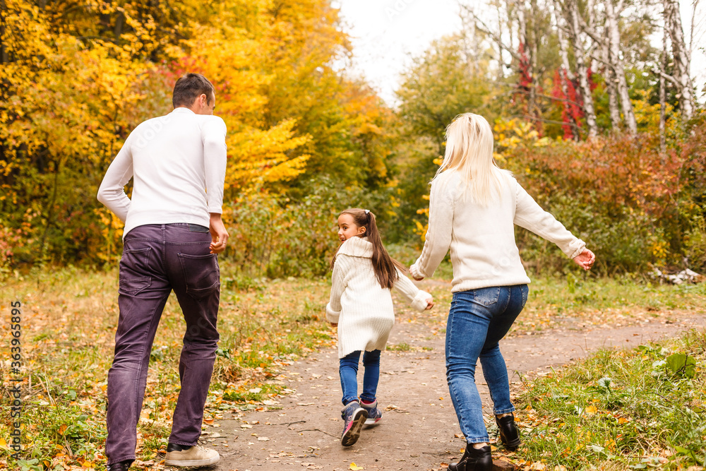 Picture of lovely family in autumn park, young parents with nice adorable daughter playing outdoors, have fun on backyard in fall, happy family enjoy autumnal nature