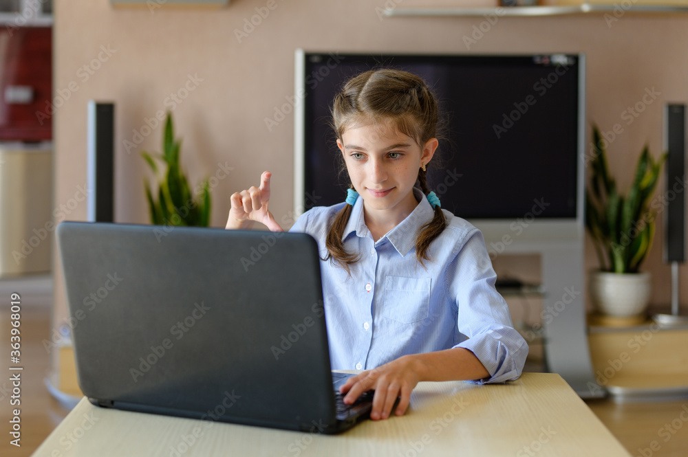 Girl sitting with a laptop. Communicates on the Internet and shows a hand gesture Girl sitting with a laptop. Communicates on the Internet and shows a hand gesture