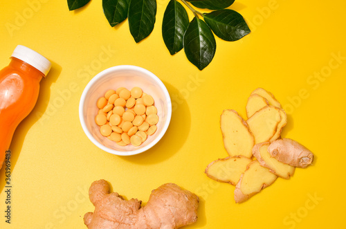 Ginger in different conditions: fresh, dry root, pills and cut plant on pastel yellow orange background.