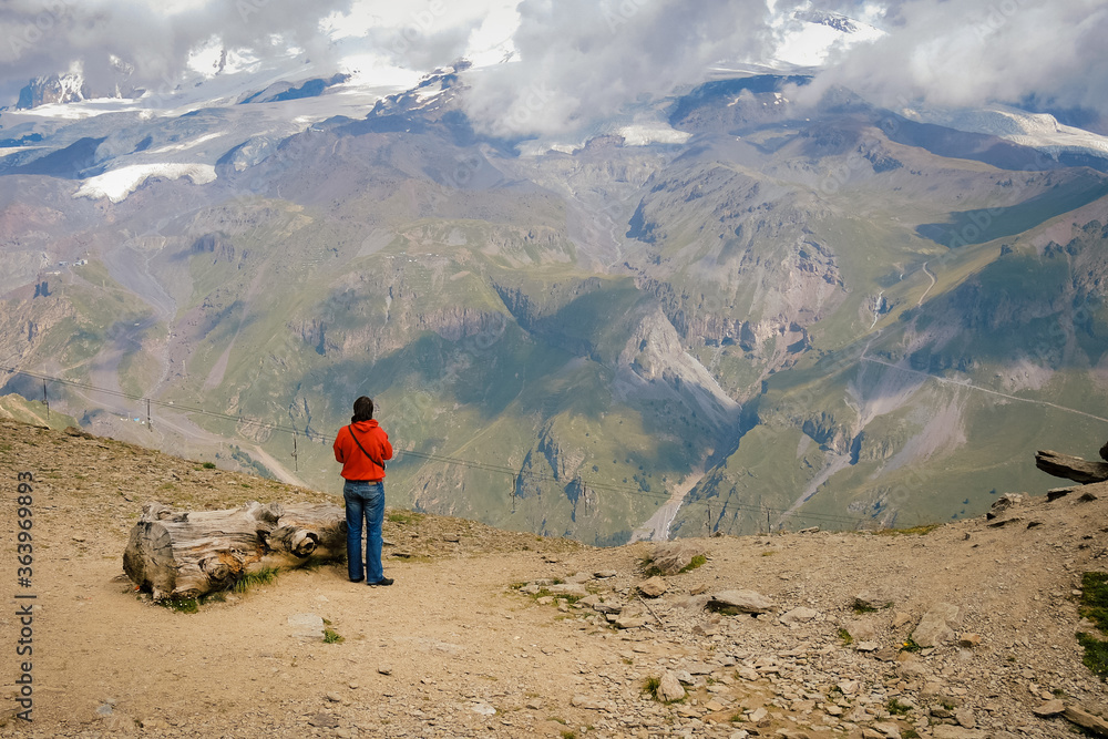 Man looks at mountains, the man mountains in the background Man looks at mountains, the man mountains in the background