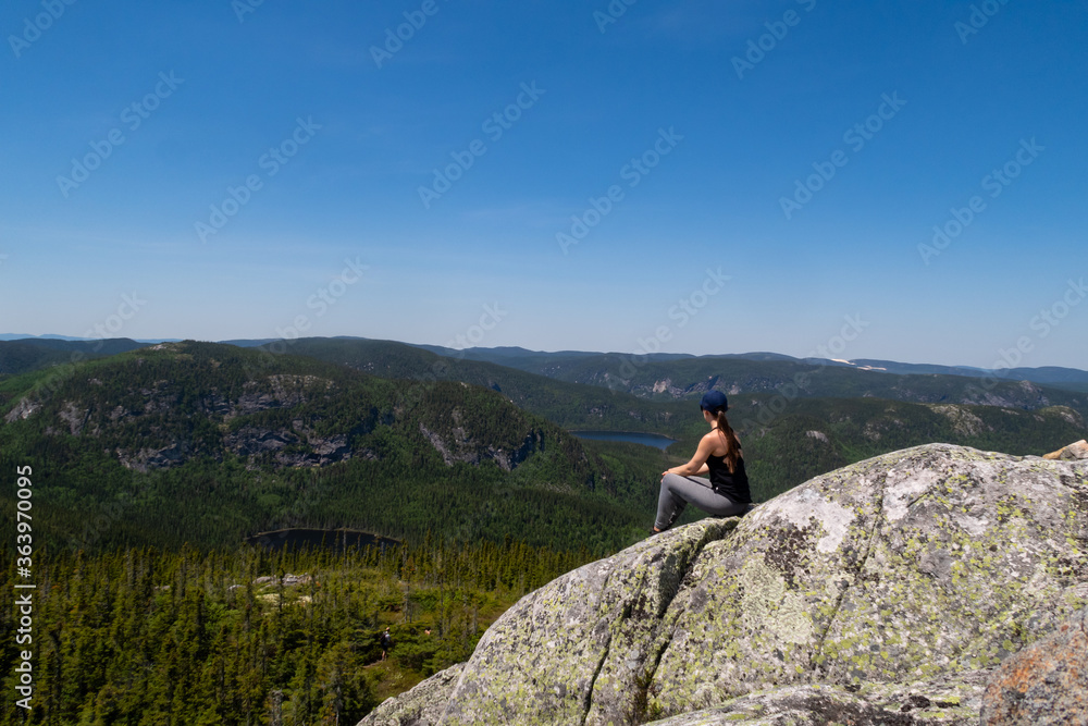 Young woman sitting at the summit of the 