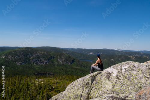 Young woman sitting at the summit of the "Mont-du-lac-des-cygnes" in Charlevoix, Quebec © jonas