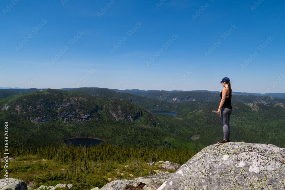 Young woman standing at the summit of the Young woman standing at the summit of the