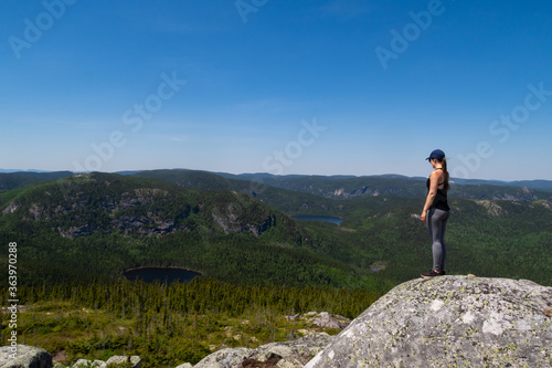 Young woman standing at the summit of the "Mont-du-lac-des-cygnes" in Charlevoix, Quebec