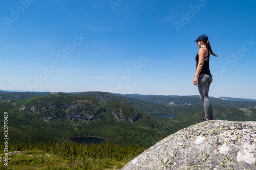 Young woman admiring the landscape at the top of the "mont de l'ours" (bear mountain) in Charlevoix, Quebec