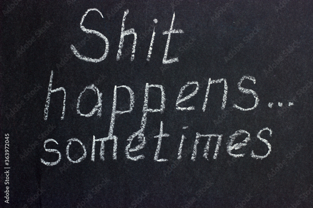 Warning inscription on chalk board: shit happens sometimes