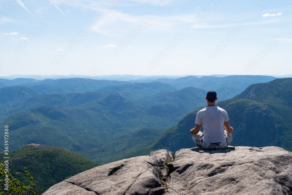 Young man admiring the landscape at the top of the 